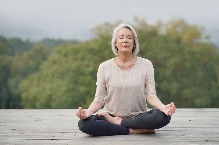 Image Woman meditating outdoors in a serene environment