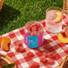 Jar of gummies labeled 'Lift' on a red and white checkered tablecloth with peaches and a glass of water..; Flavor: Dragon Fruit;
