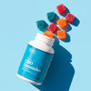 An open white bottle of Bluebird Botanicals CBD Gummies with a bright blue label, shown on a light blue background with several colorful gummies floating above it.; Strength: 100 mg;