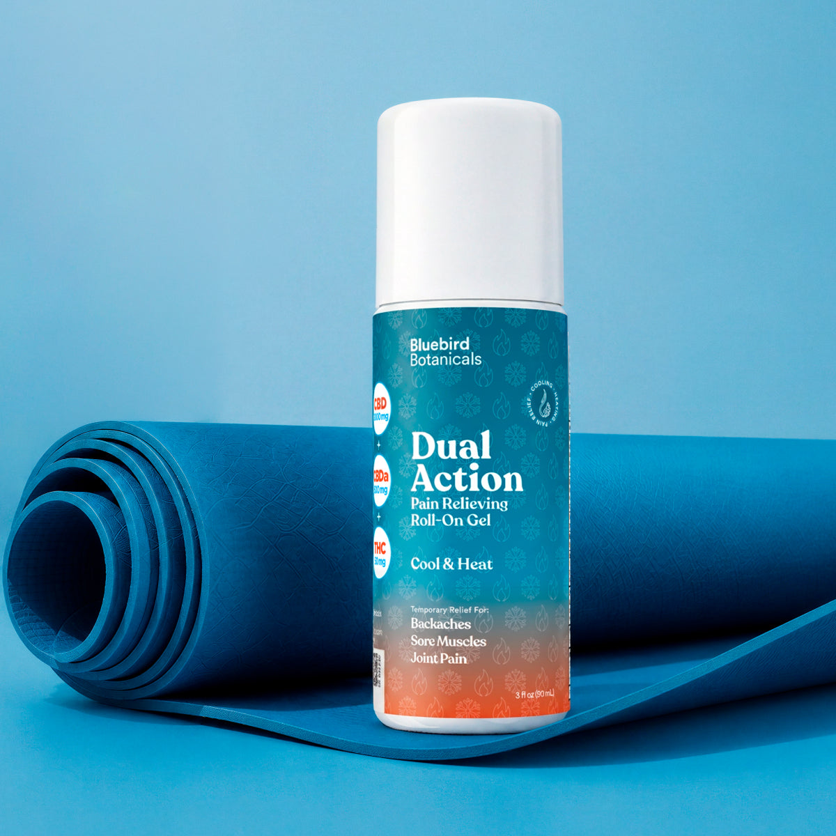 A roll of blue massage gel sits behind a cylindrical bottle of Bluebird Botanicals Dual Action Pain Relieving Roll-On Gel, set against a solid blue background.